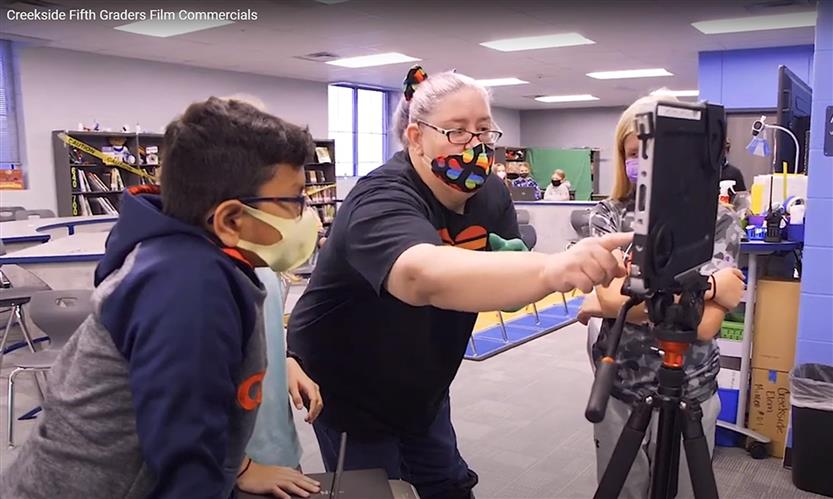 Teacher helps students film video
